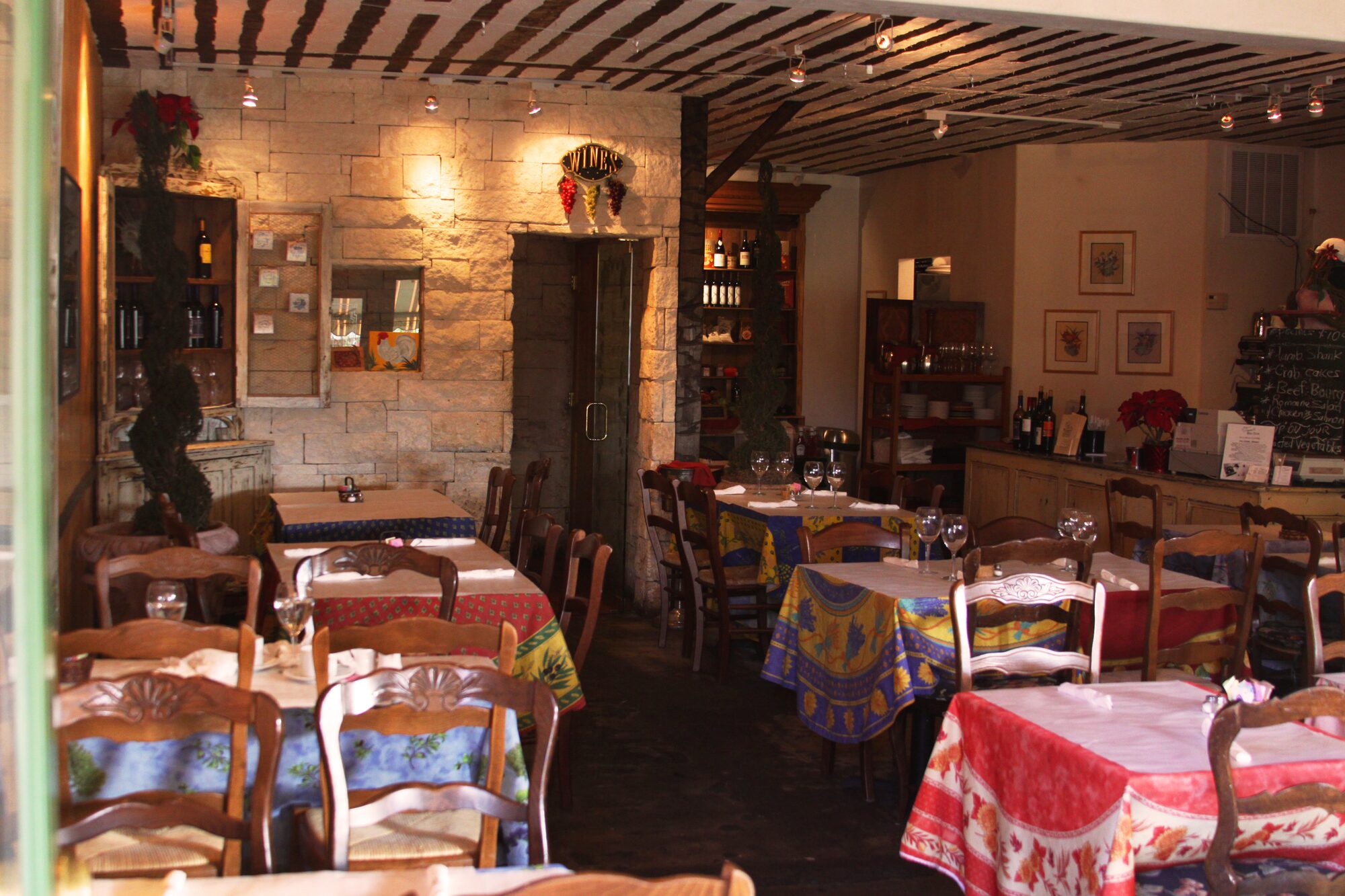 The dining room at Vincent Market Bistro, with Provençal linens and exposed beams